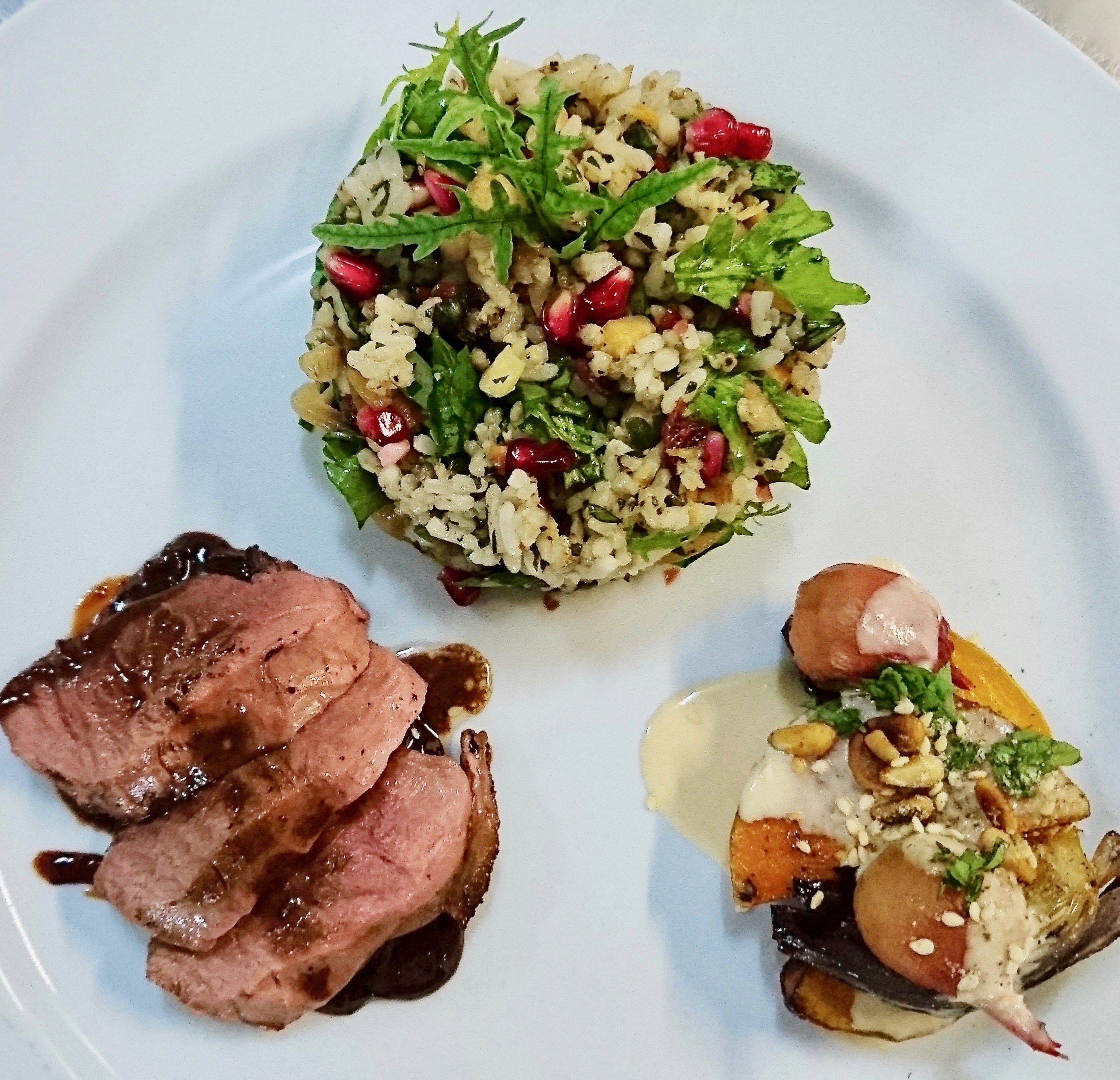 Sliced seared duck breast with wild sourplum sauce, ginger, and star anise on a plate