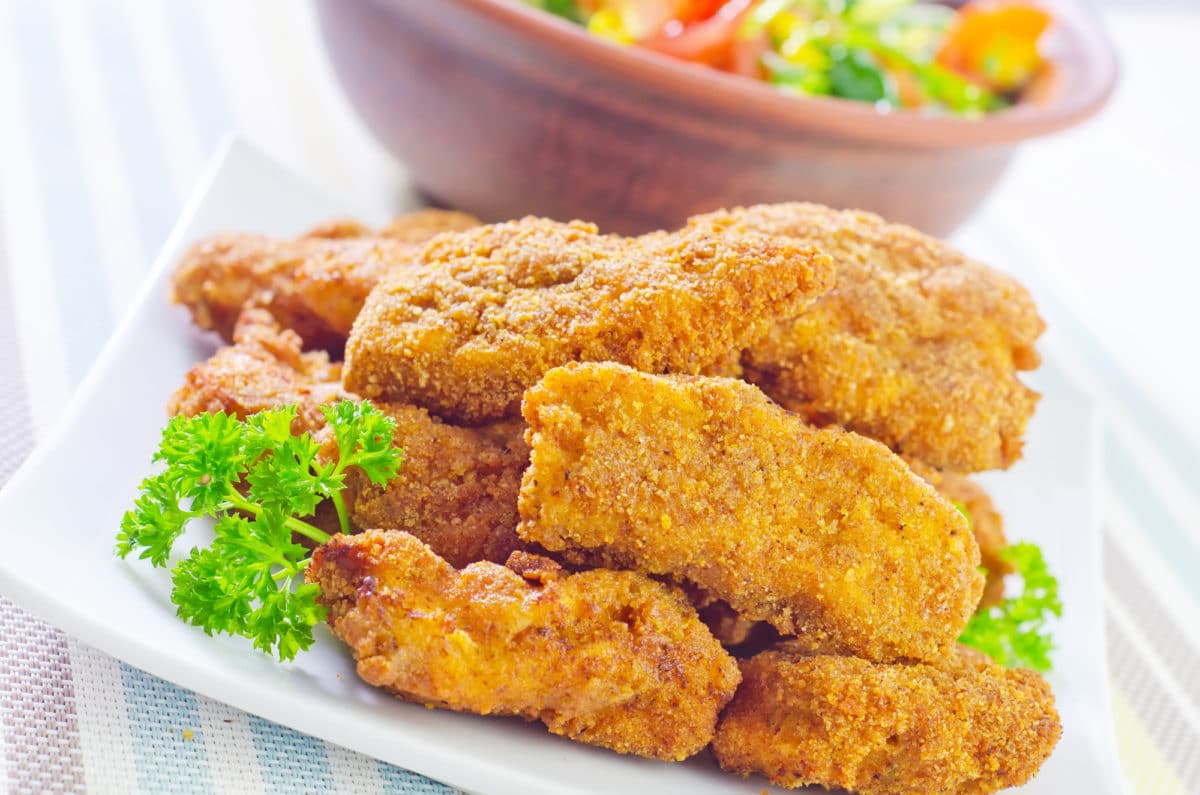 Plate of golden-brown turkey tenders served with fresh parsley.